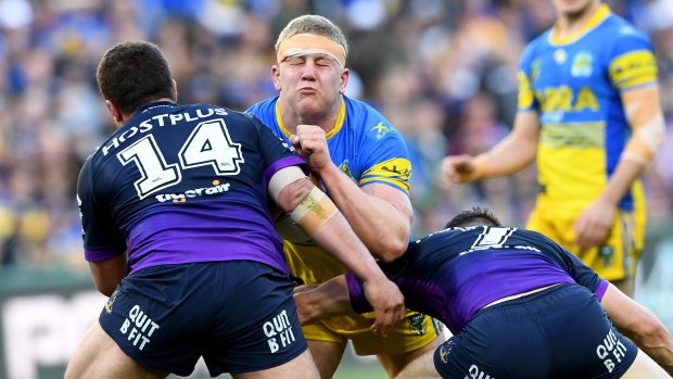 Daniel Alvaro of the Eels is tackled by Kenny Bromwich and Cooper Cronk of the Storm. 
