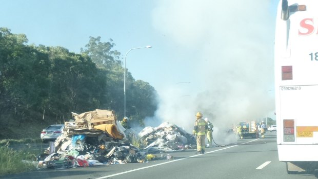 Firefighters extinguish the burning garbage on the Gateway Motorway.