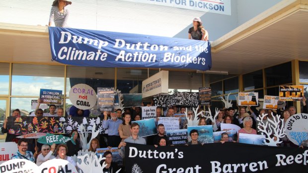 Protesters hold banners outside Peter Dutton's electorate office in Strathpine.