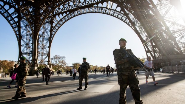 Members of the French army walk on patrol through the base of the Eiffel Tower in Paris.