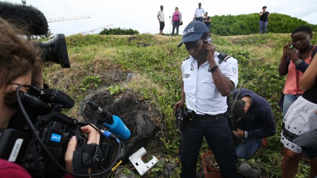 National Police Brigadier Gisele Cadar stands over the plastic object at the site where it was hidden from the media by the man who found it. 