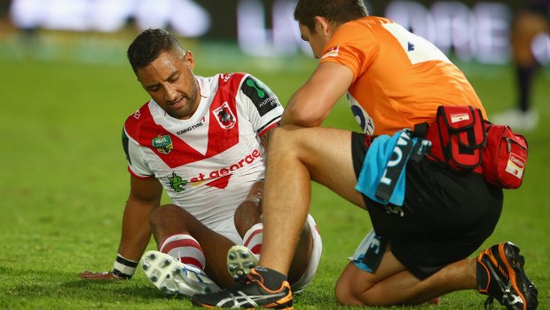 Leg fears: Dragons halfback Benji Marshall receives attention from a trainer after being tackled around the legs while kicking the ball against the Storm.