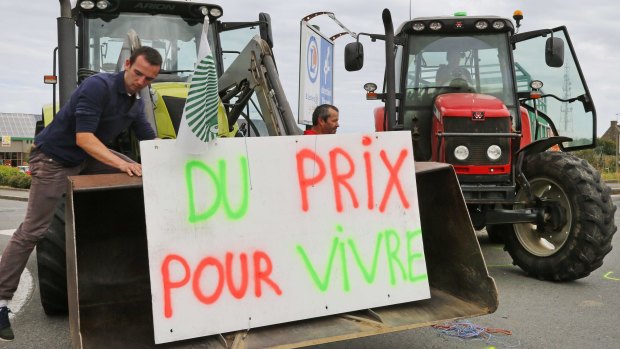 French livestock breeders on Wednesday block the entrance of a commercial centre in Saint-Malo in Brittany to protest against a squeeze in margins by retailers and food processors. The placard reads "Fair prices to live". 