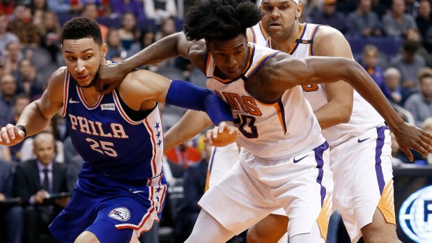 Phoenix Suns forward Josh Jackson, front right, battles with Philadelphia 76ers guard Ben Simmons (25) for a loose ball as Suns forward Jared Dudley, back right, watches.