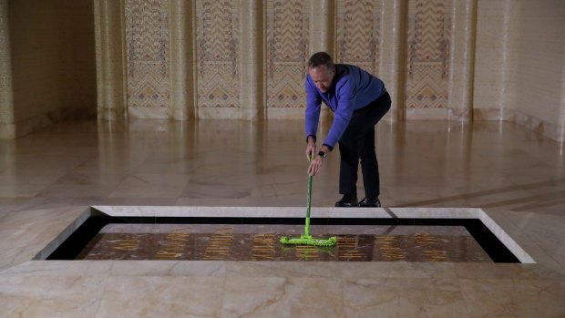 Opposition Leader Bill Shorten cleans dust from the Tomb of the Unknown Soldier.