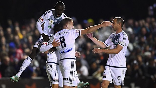 Marco Rojas of the Victory is congratulated by team mates after scoring a goal during Tuesday night's match.