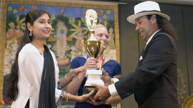 Rajashree and Bikram Choudhury present Lesli Christiansen with the first place trophy at the 2003 Yoga Expo in Los Angeles.
