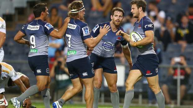 Treble yell: Waratahs players celebrate with Rob Horne after one of the winger's three tries. 