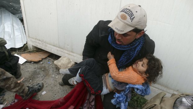A child is comforted as Iraqi security forces help trapped civilians.