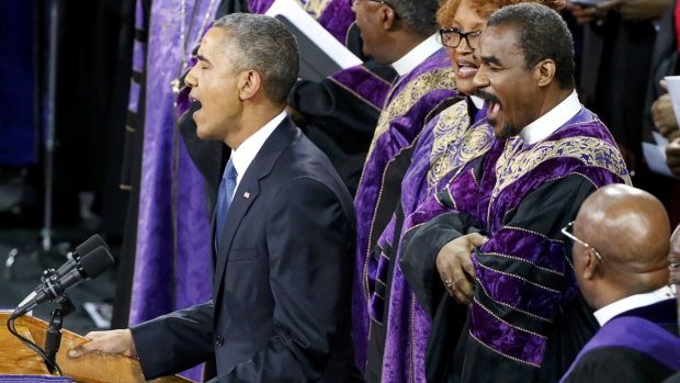 Barack Obama leads mourners at Reverend Clementa Pinckney's funeral in singing the song <i>Amazing Grace</i> in June.