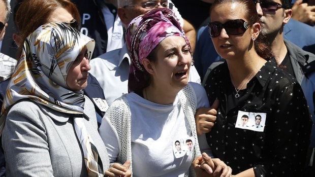 Relatives of police officers Feyyaz Yumusak and Okan Acar mourn during their funeral procession in Sanliurfa, Turkey on Thursday.