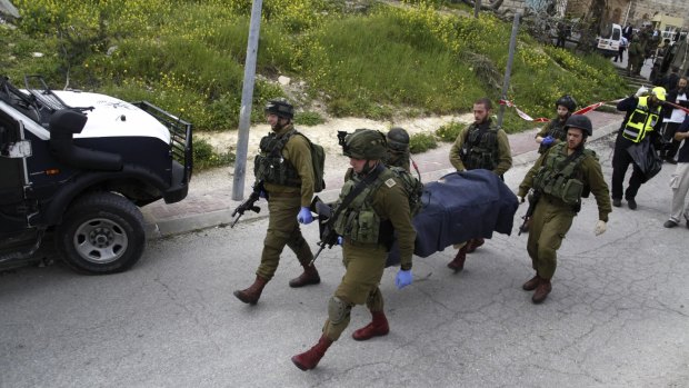 Israeli soldiers carrying the body of the Palestinian.