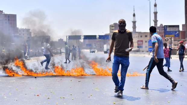 Muslim brotherhood supporters throw rocks at a protest to mark the second anniversary of the military's overthrow of Islamist President Mohammed Morsi.