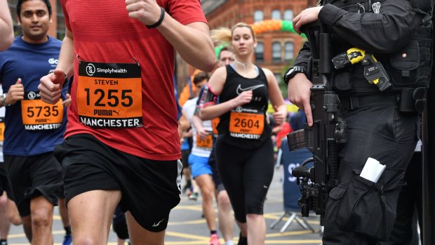 Armed police watch runners during the Great Manchester Run on Sunday.
