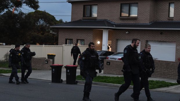 Police leave the Greenacre home after arresting Mr Hawat on Thursday morning.