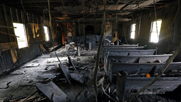 Burnt pews, destroyed musical instruments, Bibles and hymnals are part of the debris inside the fire damaged Hopewell MB Baptist Church in Greenville, Mississippi.