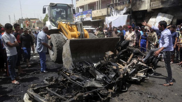 A bulldozer cleans up after the car bomb at a crowded outdoor market in the Iraqi capital's eastern district of Sadr City.