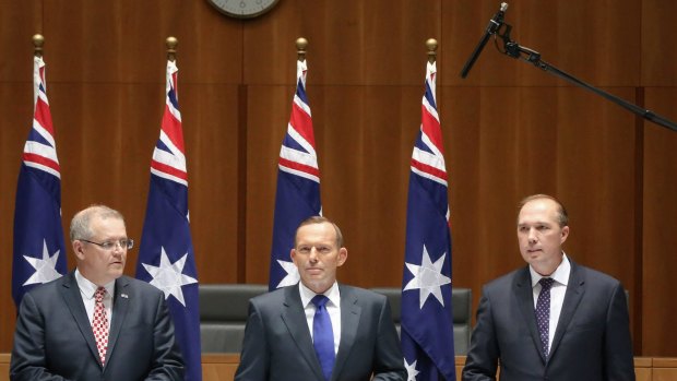 A boom microphone picks up the private conversation of former prime minister Tony Abbott (centre) and Immigration Minister Peter Dutton (right) where they joked about rising sea levels, at Parliament House in Canberra on Friday 11 September 2015. 
