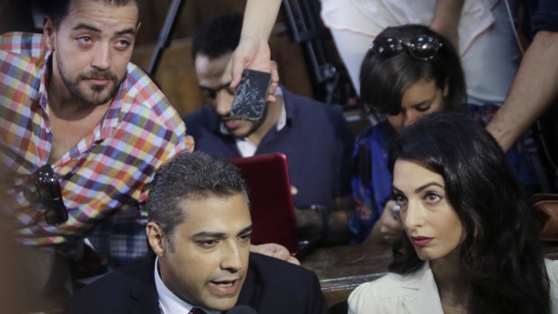 Canadian Al-Jazeera English journalist Mohammed Fahmy, left, his lawyer Amal Clooney and his Egyptian colleague Baher Mohammed, at top left, speak to media before their verdict in a courtroom in Cairo.