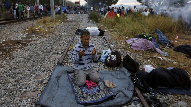A Syrian refugee prays on a rail track at the Greek-Macedonian border.