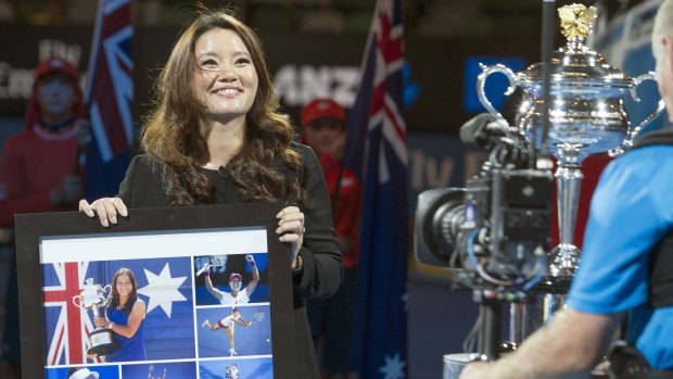 Family time: Australian Open champion Li Na holds a gift she was presented with during an official ceremony on Rod Laver Arena at Melbourne Park on Monday night. Li told the centre court crowd she was expecting her first child with her husband and former coach Jiang Shan. 