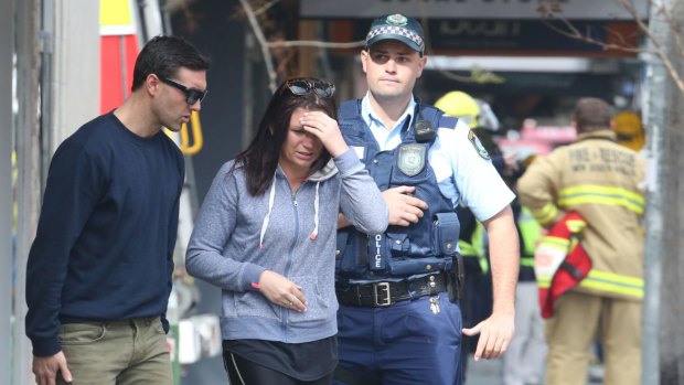 A visibly upset couple arrive at the site of a building fire in Darling street Rozelle this morning. 