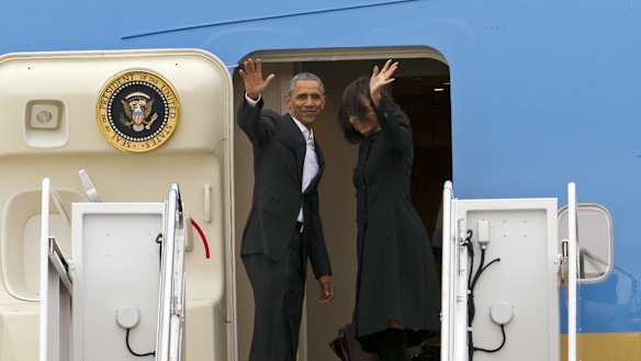 President Barack Obama, accompanied by first lady Michelle Obama, waves while boarding Air Force One before their departure  at Andrews Air Force Base, Maryland. 