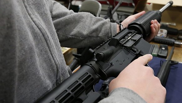 A man holds a semi-automatic assault rifle at the Rocky Mountain Gun Show in Sandy, Utah.