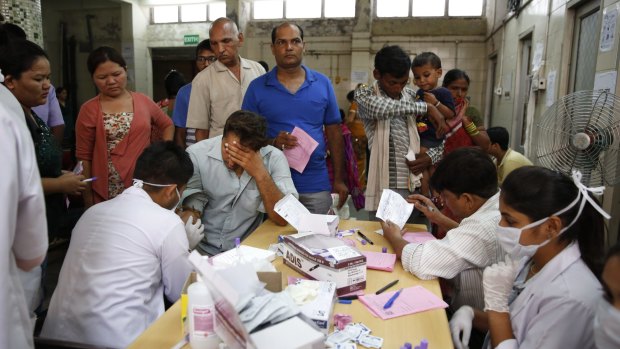 Indians suffering from fever get their blood test for dengue in New Delhi.