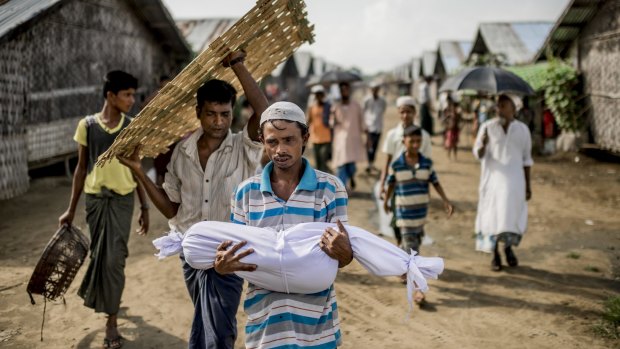 Noor Bashar carries the body of his one-year-old nephew, Mohamad Noor, for burial at a camp for Rohingya in Sittwe, Myanmar, in June 2015. 