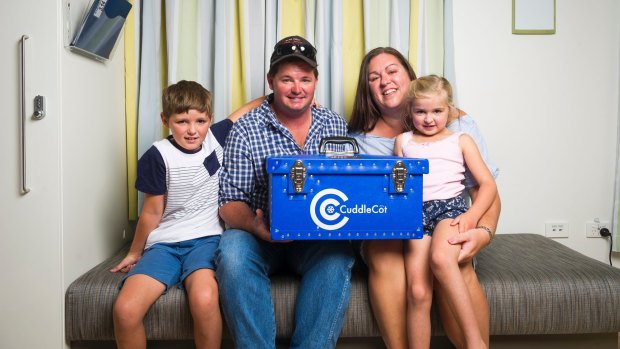 The Baker family from Tumut: William, 8, Jye, Ashlee and Elsie, 5, hold the newly donated Cuddle Cot with a plaque remembering their stillborn baby brother, Jack. 