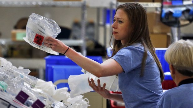 Chelsea Clinton works with volunteers preparing free medical kits for distribution around the world.