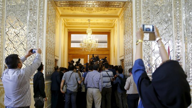 Media attempt to get photographs of British Foreign Secretary Philip Hammond before a meeting with the Iranian Foreign Minister ahead of the reopening of the British mission.