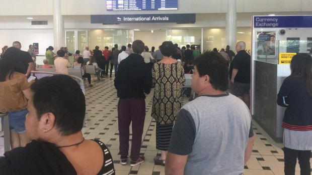 Inbound travellers are facing lengthy delays after machines at customs. A large crowd has gathered in the international arrivals section.