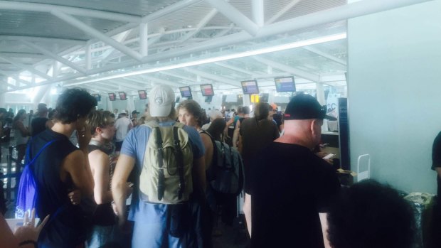 Passengers on Virgin Australia's cancelled Brisbane flight queue to rebook flights at Denpasar Airport.
