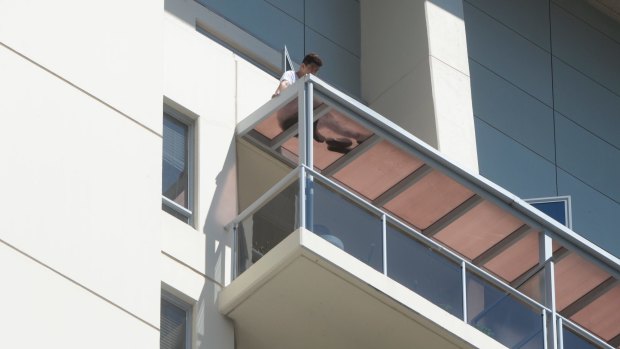A man on top of a balcony in Chatswood after a woman's body was found below.