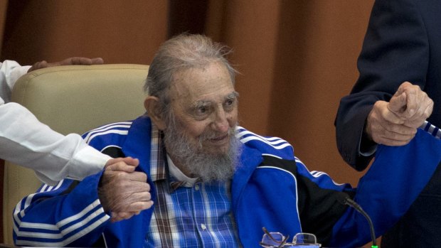 Fidel Castro clasps hands with his brother, Cuban President Raul Castro, right, and second secretary of the Central Committee, Jose Ramon Machado Ventura.