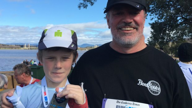 Liam, 11, and father Paul Tainsh, at the end of the 14km Canberra Times fun run on Sunday.