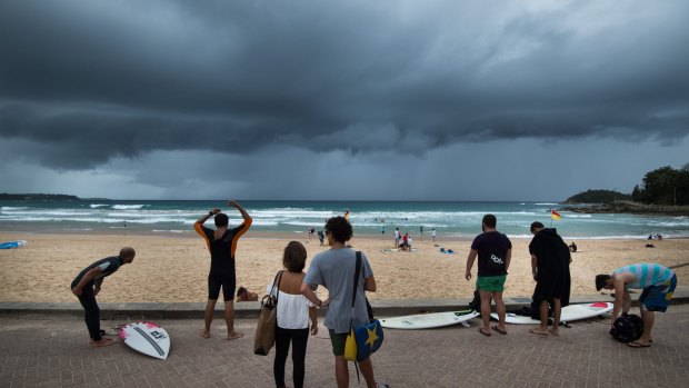 Beachgoers watch rain clouds roll in as Sydney copped a soaking on Monday.