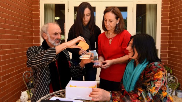 Jerzy Dyczynski, left, and Angela Dyczynski, right, with Maria Condipodero and Sarina Giglia, open the packet of sunflower seeds harvested from the MH17 cockpit crash site on the outskirts of Rassypnoe in East Ukraine. 