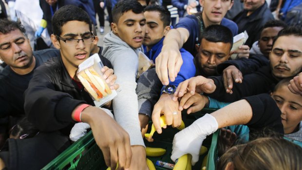 Migrants grab for food at a reception centre for refugees and asylum seekers in Berlin.