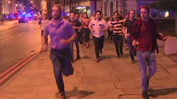 A man holds his beer while people flee terror attacks in London on Saturday. 