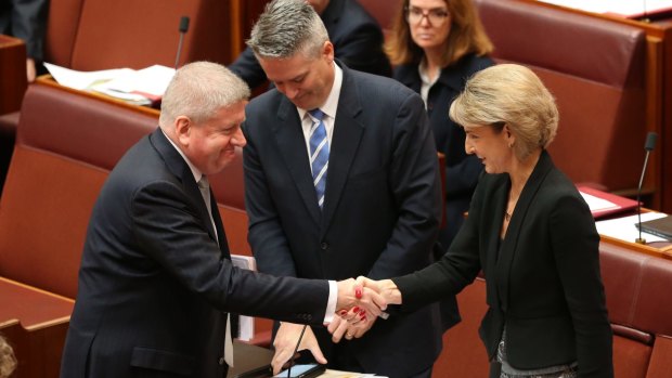 Employment minister Senator Michaelia Cash is congratulated by Communications Minister Mitch Fifield and Finance Minister Senator Mathias Cormann for the passing of the ABCC bill on Wednesday.