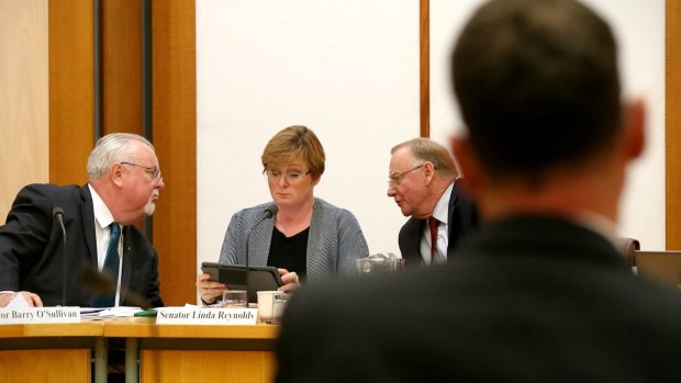 Senators Barry O'Sullivan, Linda Reynolds and Ian Macdonald talk strategy during their interrogation of Solicitor-General Justin Gleeson.