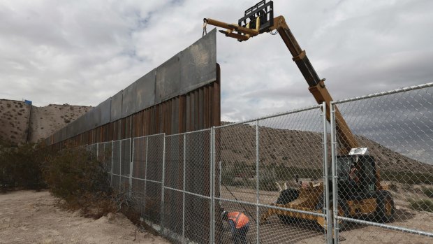 Workers raising the fence in the Mexico-US border area separating the towns of Anapra, Mexico and Sunland Park, New Mexico, in November.