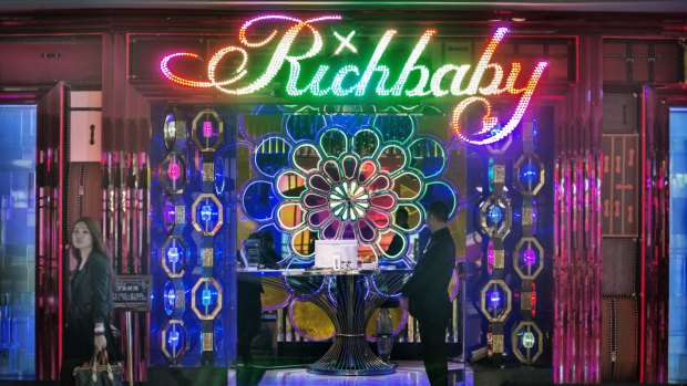 A young woman with a Louis Vuitton handbag leaves 'Richbaby' a nightclub close to the Xintiandi shopping area. The club mainly attracts Chinese patrons rather than western expatriates and reportedly is the site of 'champagne wars', where high rolling customers compete to buy up the largest bar tab.