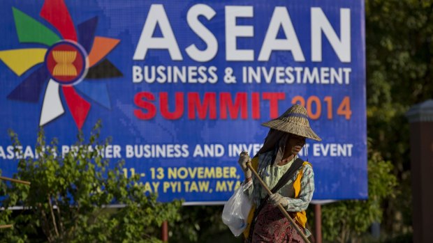 Sprucing up for summit: A sweeper cleans a road in front of a billboard for the summit in Naypyitaw.