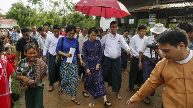 Myanmar pro-democracy leader Aung San Suu Kyi walks in Warheinkha village outside Yangon campaigning ahead parliamentary elections in November. 