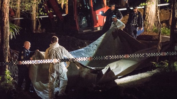 NSW police and forensic services cover the suspected remains of Matthew Leveson in the Royal National Park at Waterfall in May.