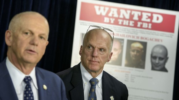 FBI's Joseph Demarest (right) listens while US Attorney David Hickton speaks at the briefing. 